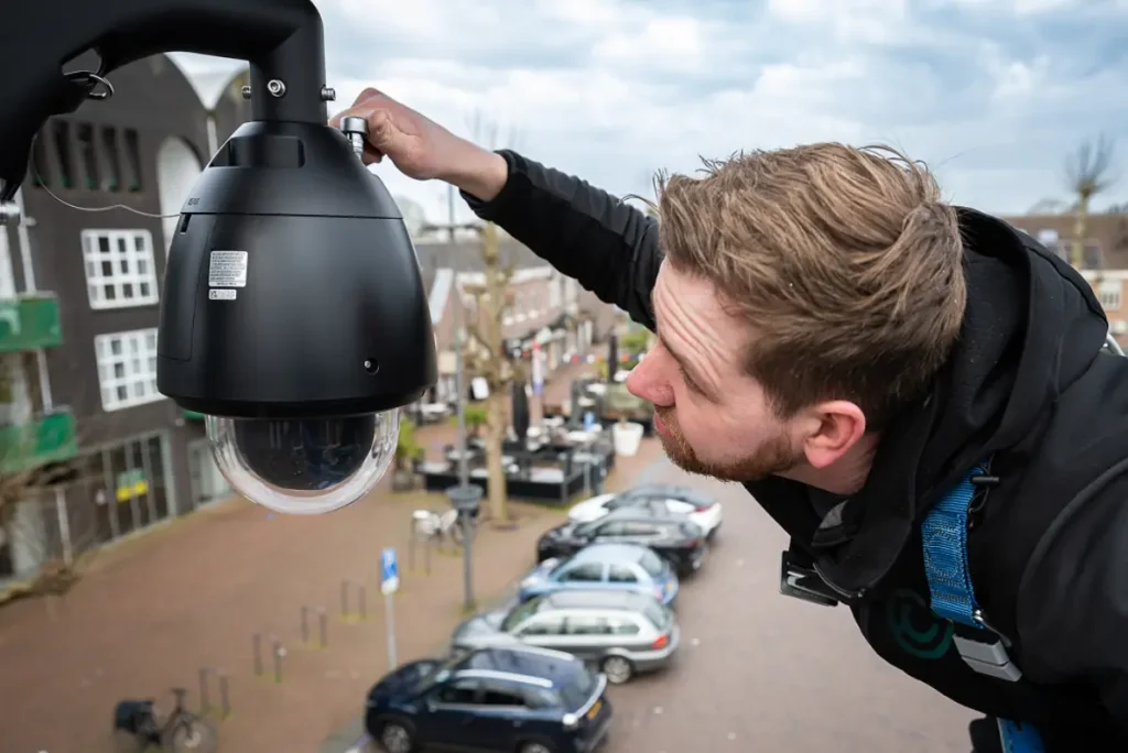 HTR-monteur installeert een beveiligingscamera op hoogte